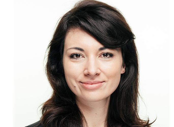 Hana Ryan Wilson softly smiling in front of a white background