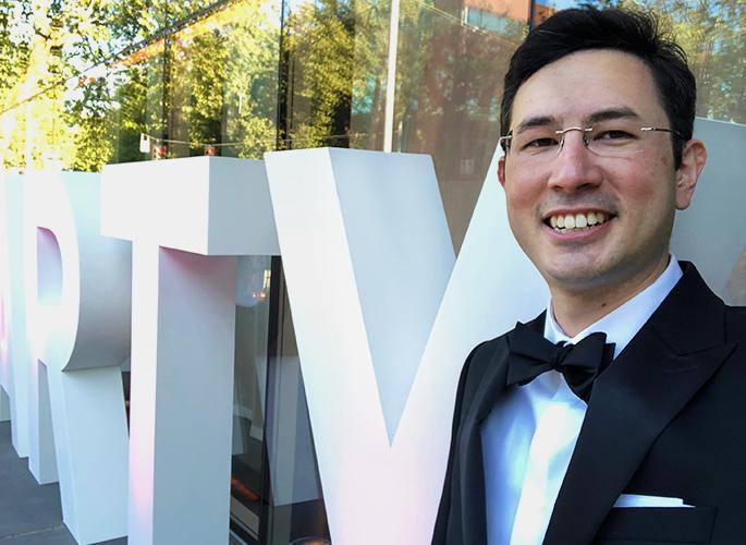 Selfie-style picture of Lokela Alex Minami in front of the Seattle Opera Company "SO PARTY" sign