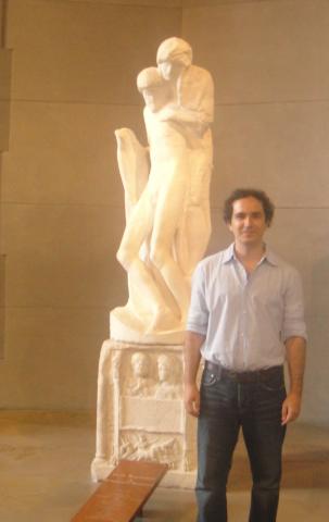 Professor of Spanish and Portuguese Antonio Rueda beside a statue