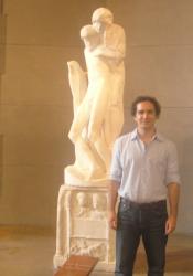 Professor of Spanish and Portuguese Antonio Rueda beside a statue